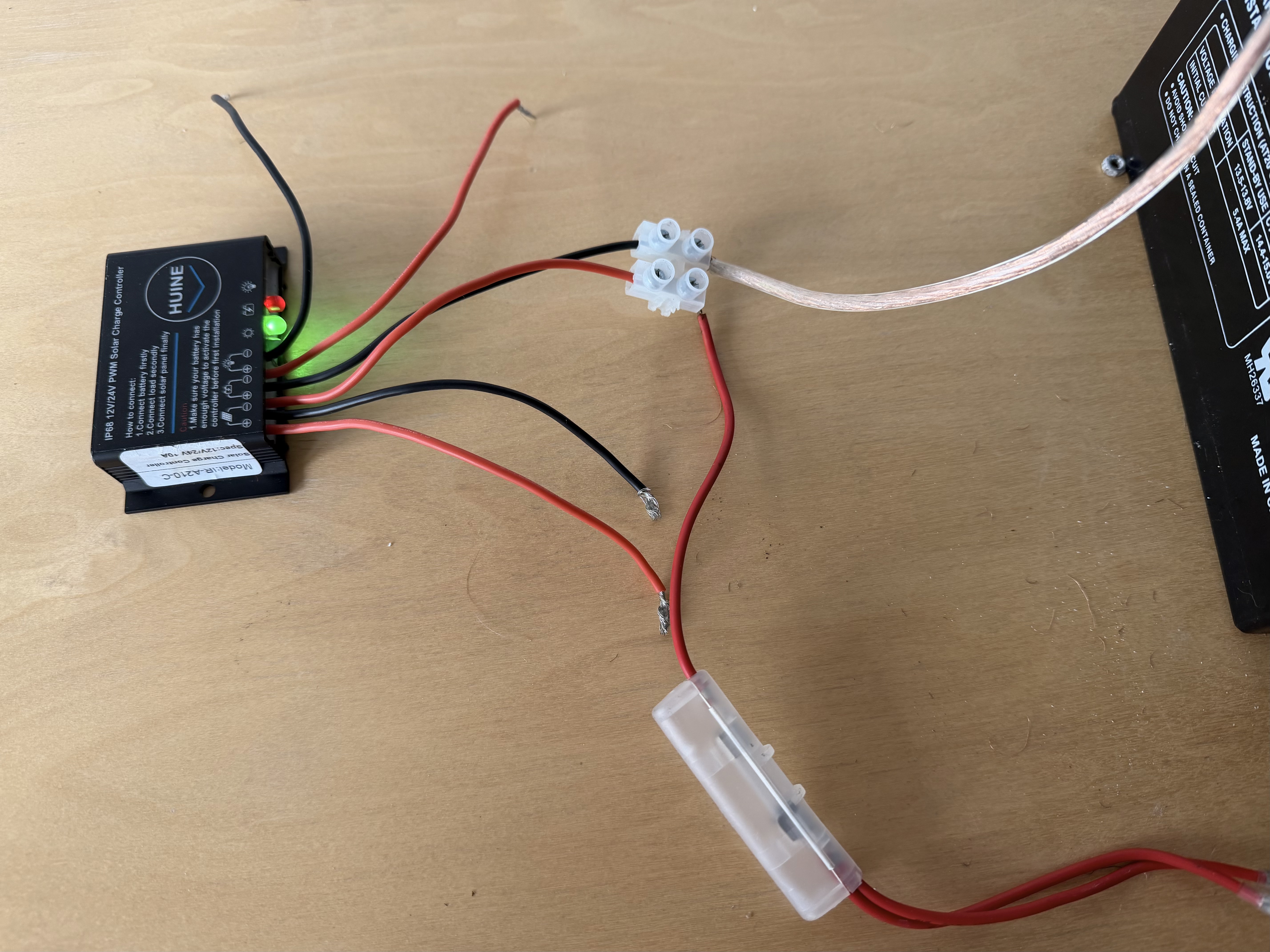 Photo showing the connection between the battery system, solar controller and inline fuse. Photo showing the connection between the battery system, solar controller and inline fuse.